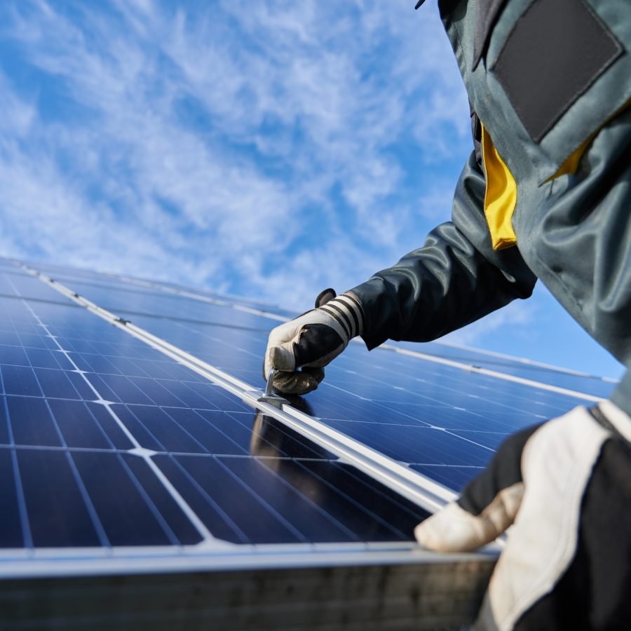 Elektriker monterer solcellepanel på tak.